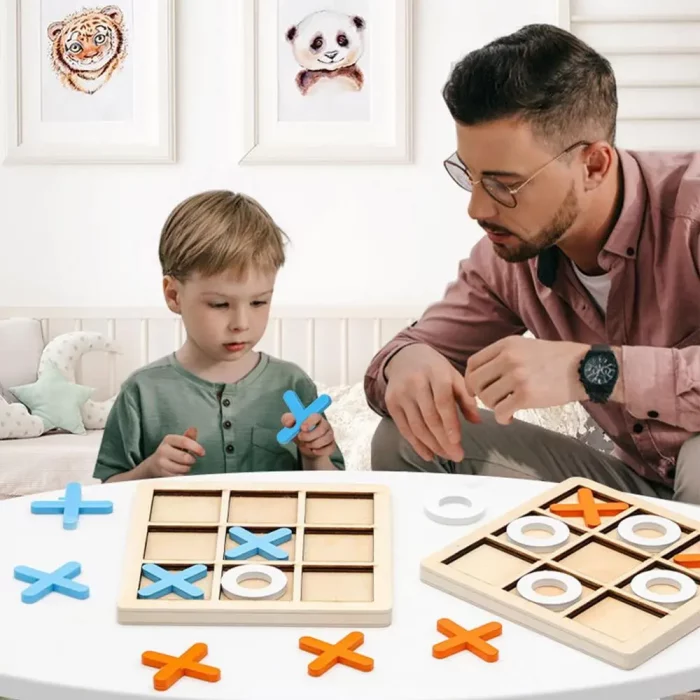 Un homme et un enfant jouant à un jeu de tic tac toe avec une planche de bois orange.